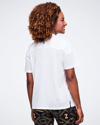 Female model, shown from the back wearing a white top and patterned black and gold leggings on a white background.
