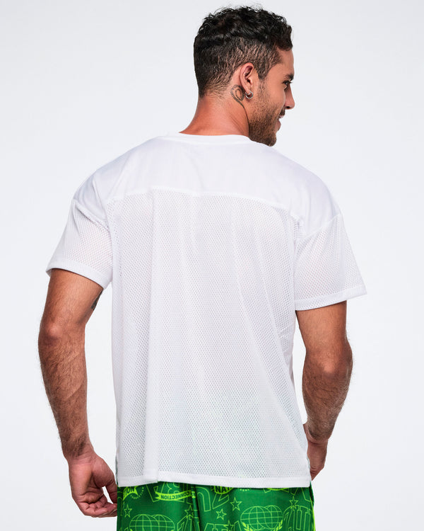 Back view of a male model wearing a white top paired with green shorts on a white background.