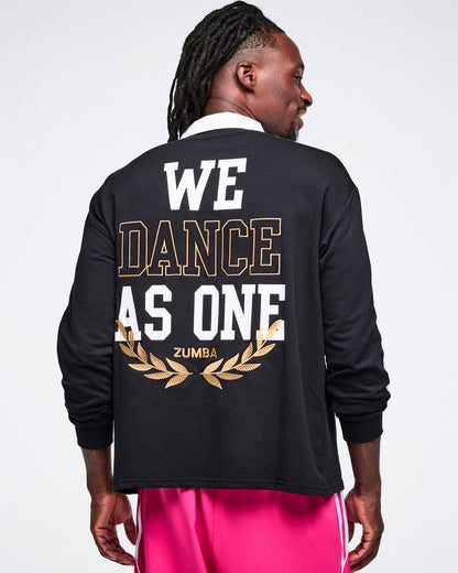 Male model wearing a black Zumba polo with 'We Dance As One' Zumba text on the back.