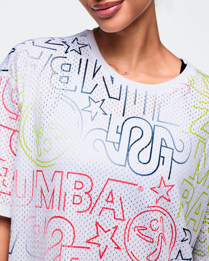 Female model wears the relaxed short-sleeve top in a close-up view, highlighting the crew neckline and colorful blue, pink, lime, and gray graphic details against a light gray background.