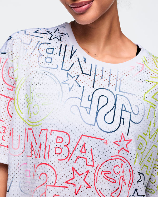 Female model wears the relaxed short-sleeve top in a close-up view, highlighting the crew neckline and colorful blue, pink, lime, and gray graphic details against a light gray background.