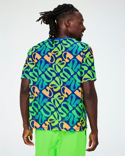 Shown from the back, a male model in the blue warped 'ZUMBA' print mesh boxy top, the print continuing across the back and short sleeves.