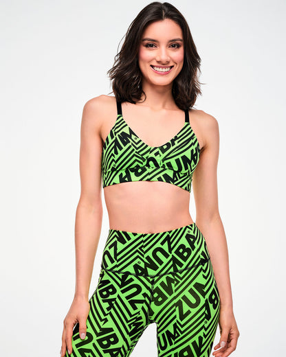 Female model wearing a green and black geometric striped print bra and matching leggings.
