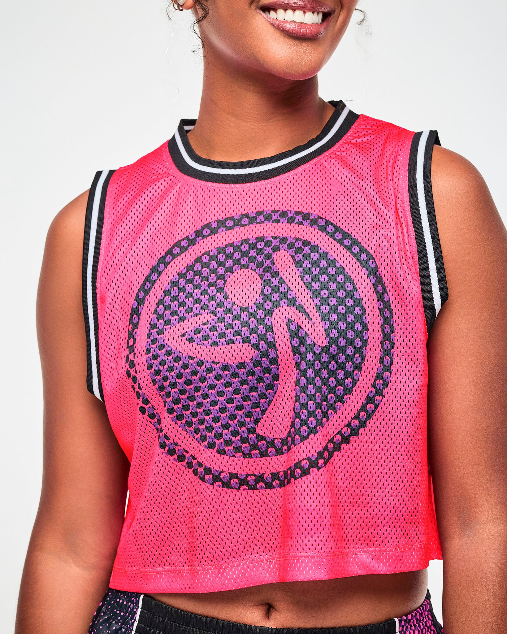 Close-up of a purple and black dot pattern Zumbito logo on a pink mesh tank.