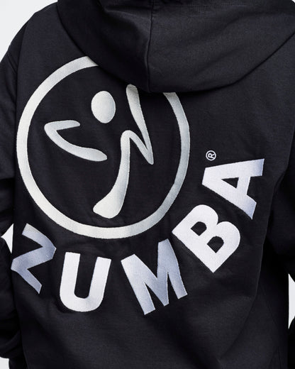 Close-up back view of a black hoodie featuring an embroidered white Zumbito logo with arched "ZUMBA" text below, against a white background.