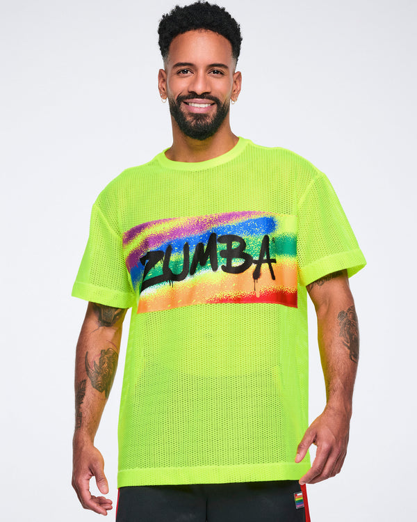 Male model wearing a bright yellow Zumba mesh top with colorful design on a white background.
