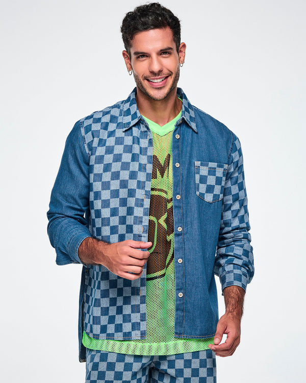 Front view of a male model wearing an open denim button-down with a checkerboard front panel, layered over a neon green mesh tank top.