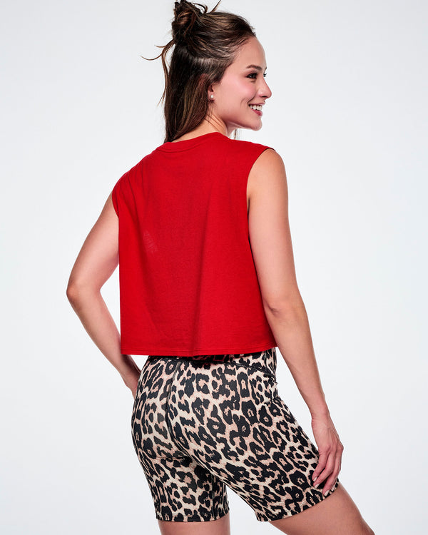 A female model shown from the back wearing a bright red sleeveless crop top and leopard-print biker shorts against a white background.