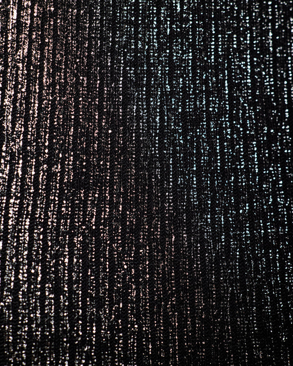 A close-up of a textured black fabric with vertical metallic silver and bronze shimmering streaks.