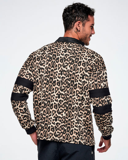 Back view of a male model wearing a long-sleeve leopard-print polo shirt with black collar, cuffs, and sleeve stripes, paired with black pants against a white background.