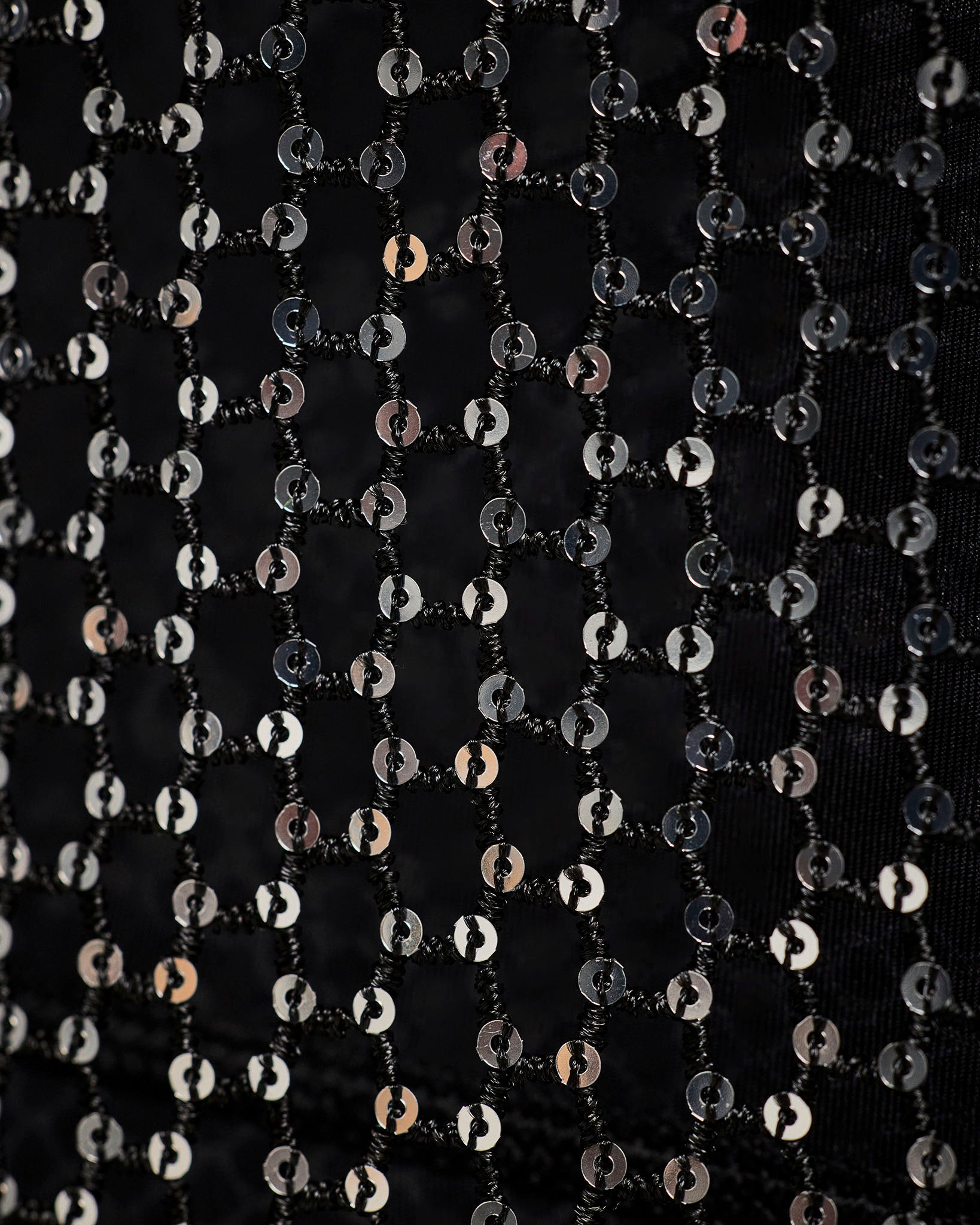 Close-up of the black sheer mesh panel with sequins, showing the chain-link pattern and the shimmering silver pattern.
