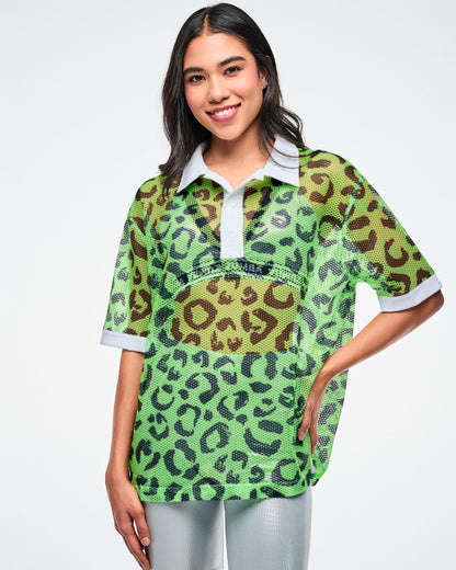 Female model wearing a green leopard-print mesh polo with a white collar paired with silver biker shorts.