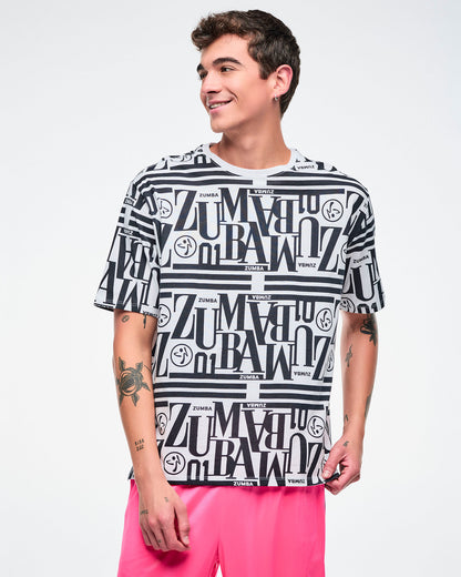 Male model wearing a black and white patterned Zumba boxy top paired with pink pants.