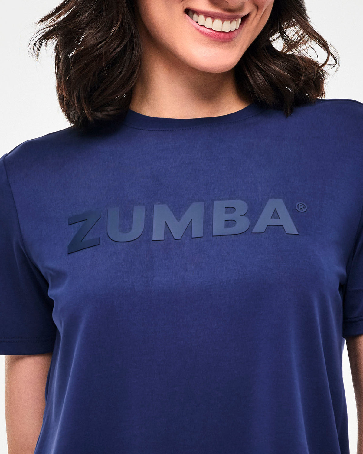 Close-up of the navy crew neck top, showing the crew neckline and raised tonal 'ZUMBA' text across the chest.