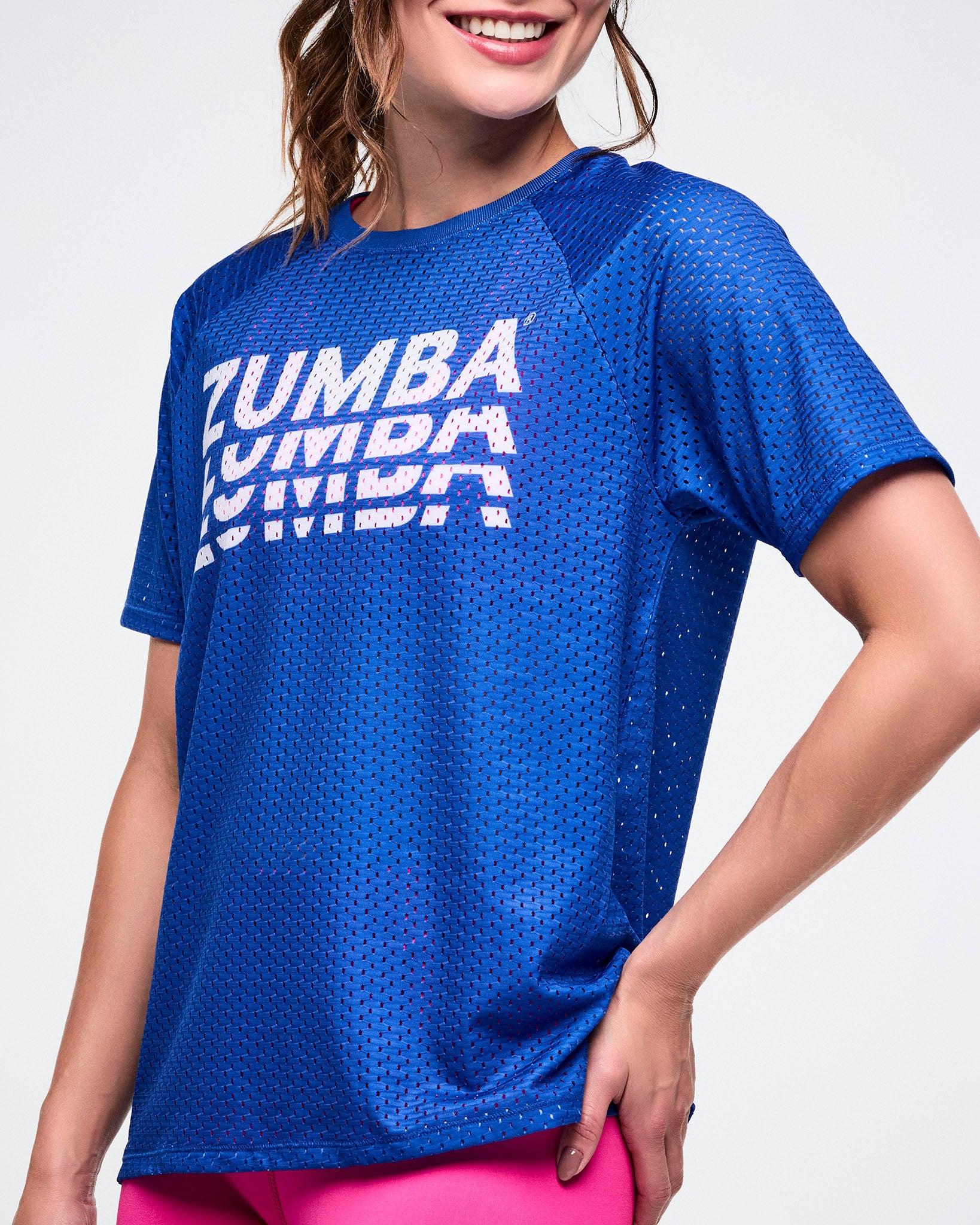 Close-up view showing a female model wearing a blue Zumba mesh top. 