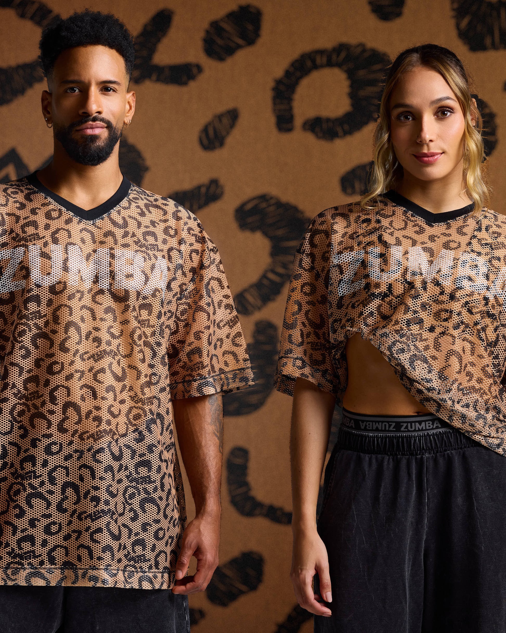 Leopard print mesh tees on male and female models with black pants against a tan leopard print backdrop.