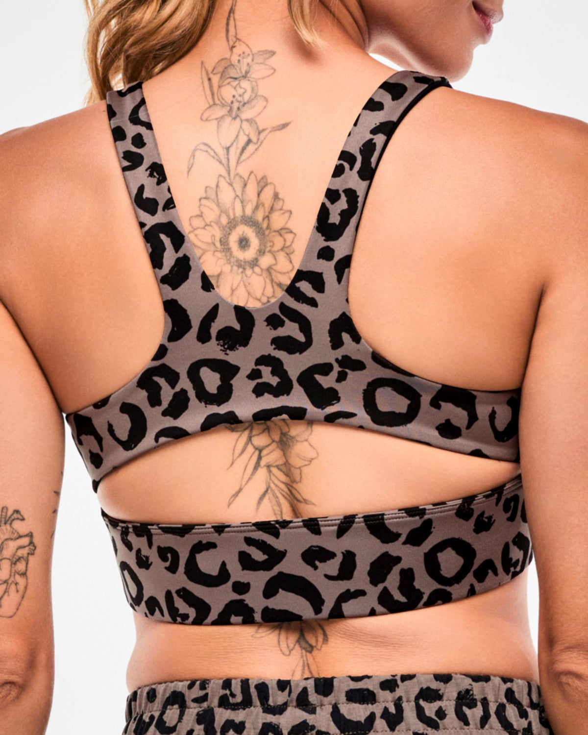 Close-up back view of a brown leopard print longline bra, showing the racerback straps and keyhole cutout above the wide underband.