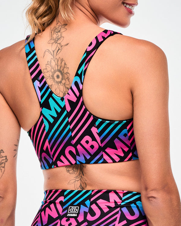 Close-up of the criss-cross back of a black sports bra with a pink, aqua, and black diagonal 
