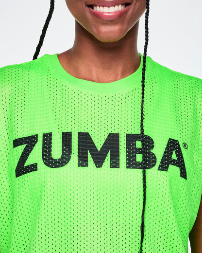 Close-up of a female model wearing a bright green Zumba mesh top with a black ZUMBA lettering across the chest.