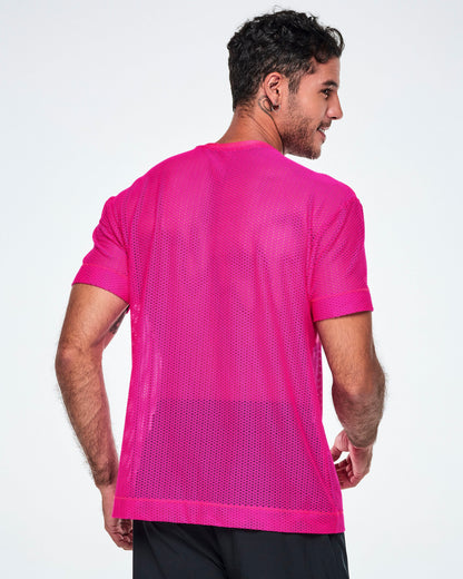 Back view of a male model wearing a bright pink Zumba mesh top, paired with black pants.