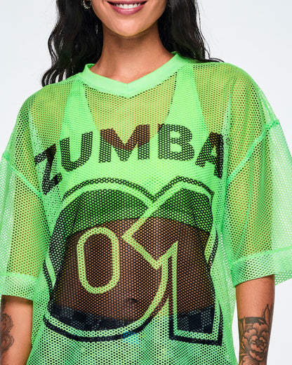 Close-up detail of a female model wearing a green mesh Zumba top, with a large black "ZUMBA 01" printed on the front.