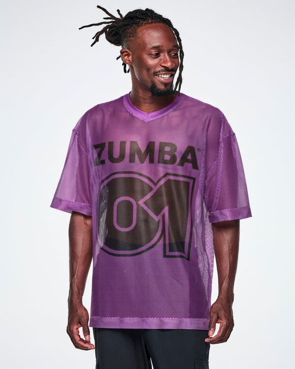 A male model wearing a purple mesh Zumba top with a large black 