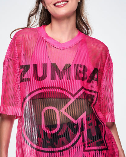 Close-up detail of a female model wearing a pink mesh Zumba top, with a large black "ZUMBA 01" printed on the front.