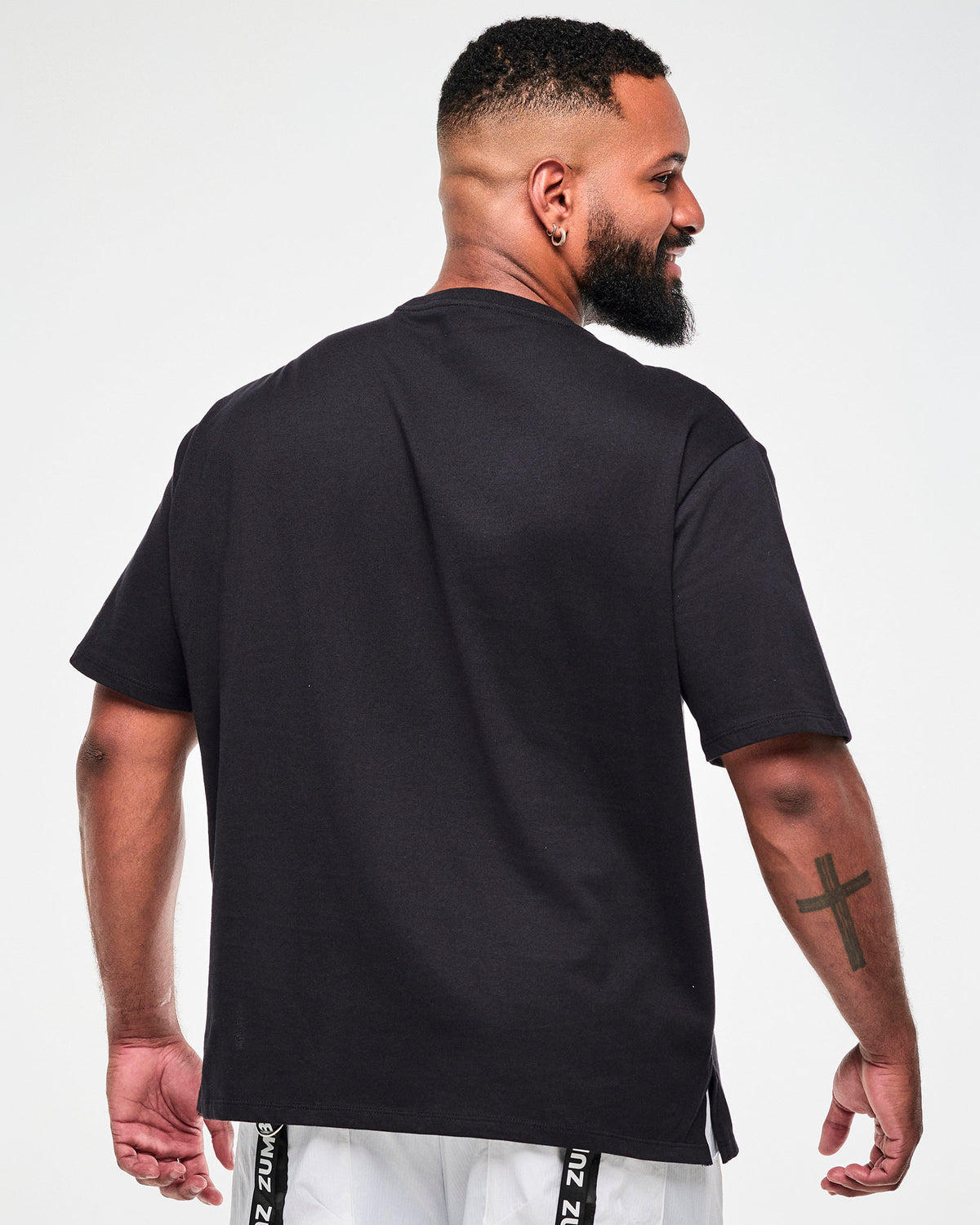 Back view of the black oversized T-shirt, male model, showing the oversized fit.