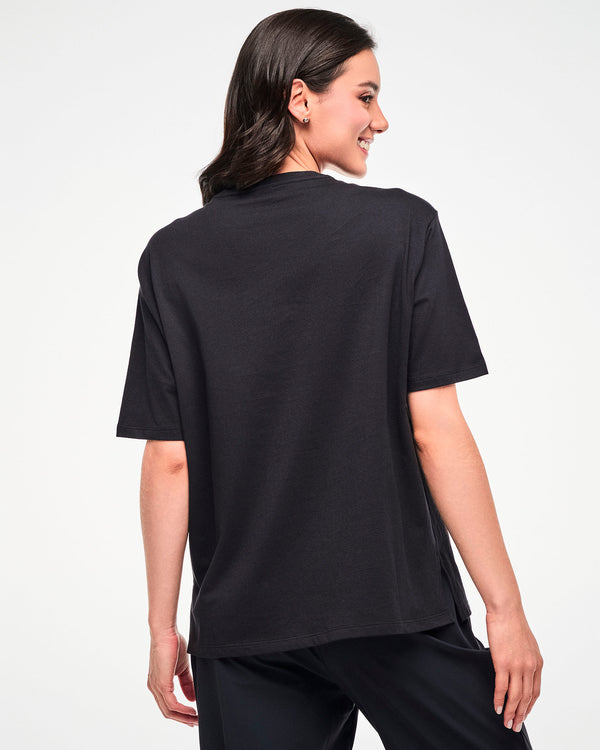 Back view of the black oversized T-shirt, female model, highlighting the relaxed silhouette.