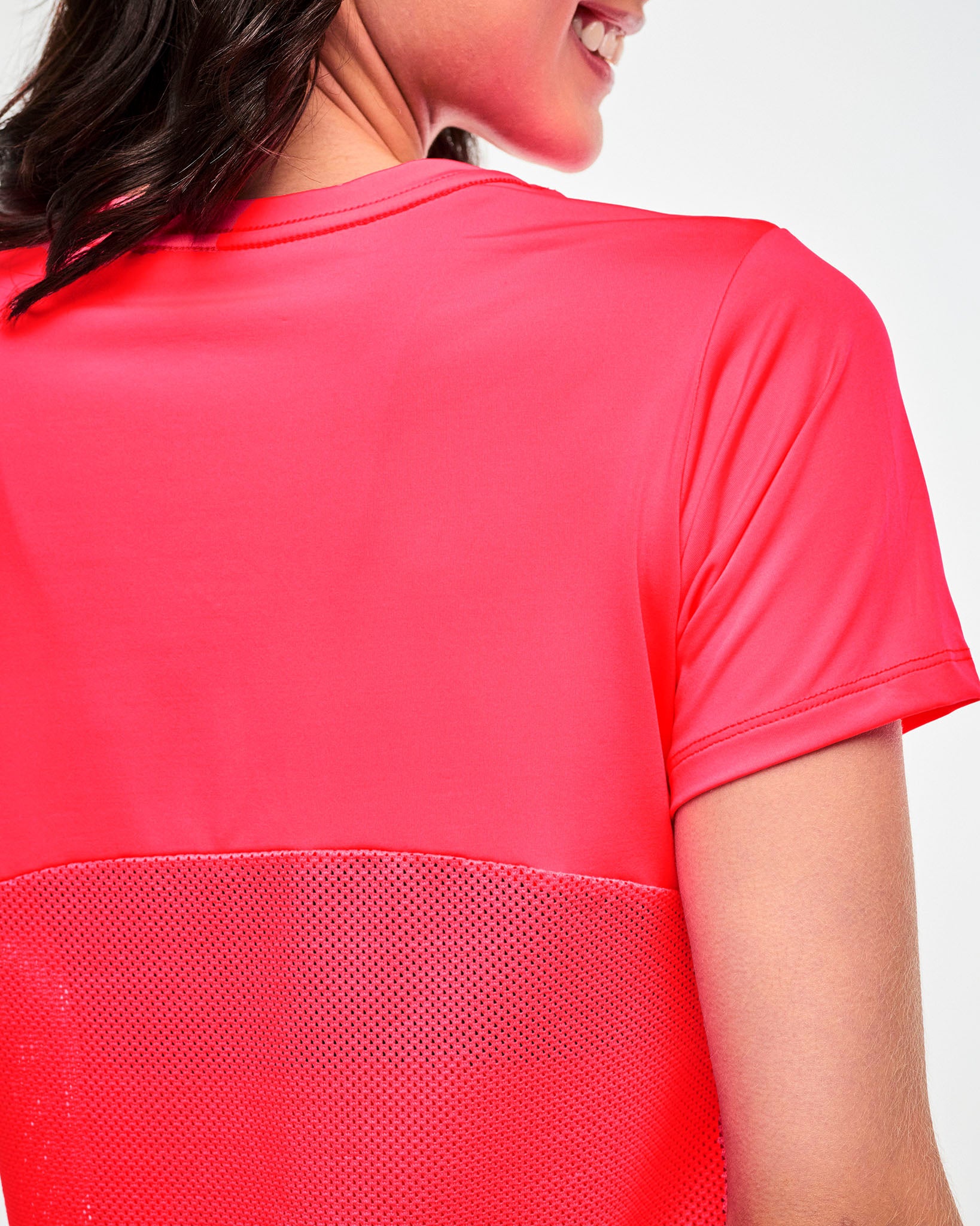 Close-up of the mesh back panel on a pink tee.