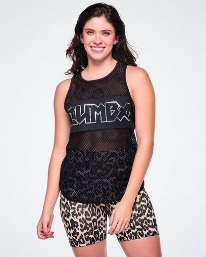 A female model wearing a black mesh   tank with silver ZUMBA text in a metal-like font, paired with tan, leopard print biker shorts.