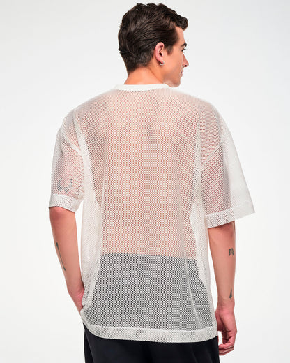Back view of the white mesh oversized top, male model, showing the sheer fabric and dropped hem.