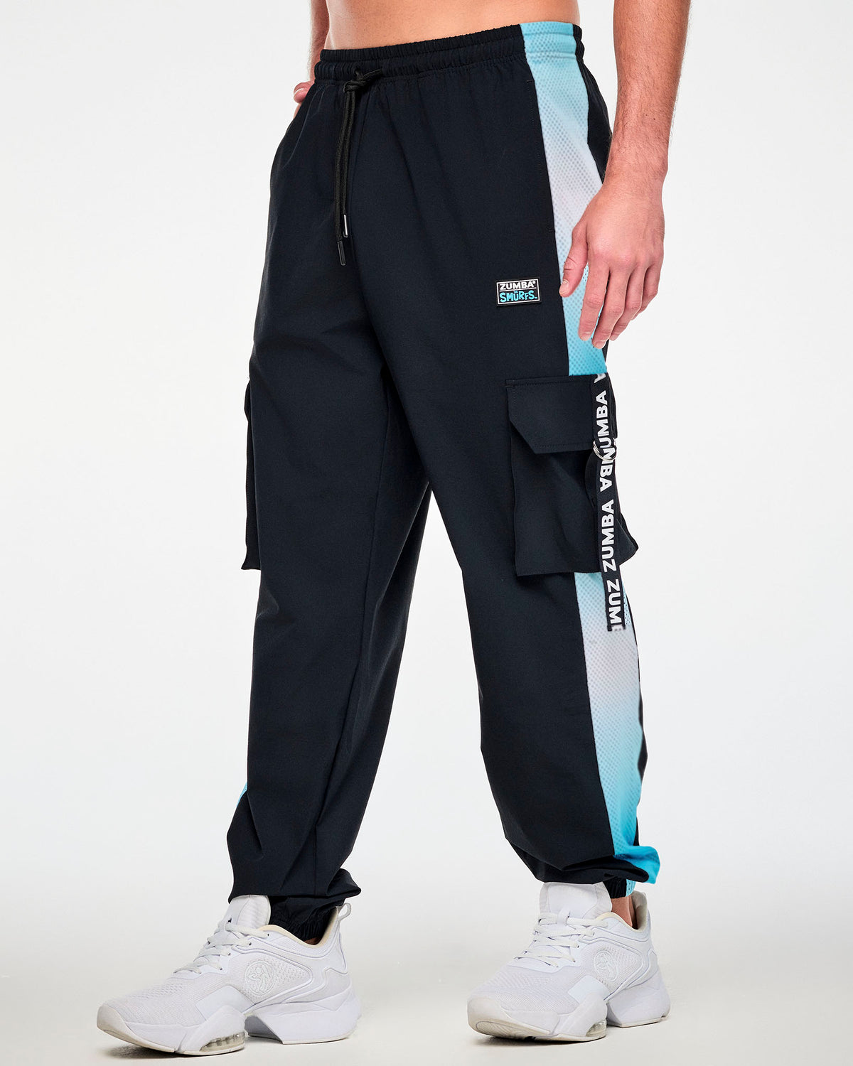 Male model in the black cargo pants, shown in side view with the light blue ombre mesh side panel and a 'ZUMBA' webbing strap on the cargo pocket.