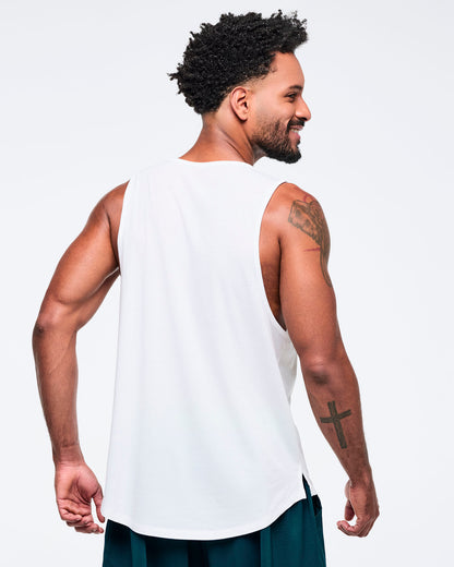 Back view of the white racerback tank on a male model, showing the plain back and deep armholes, paired with teal pants.