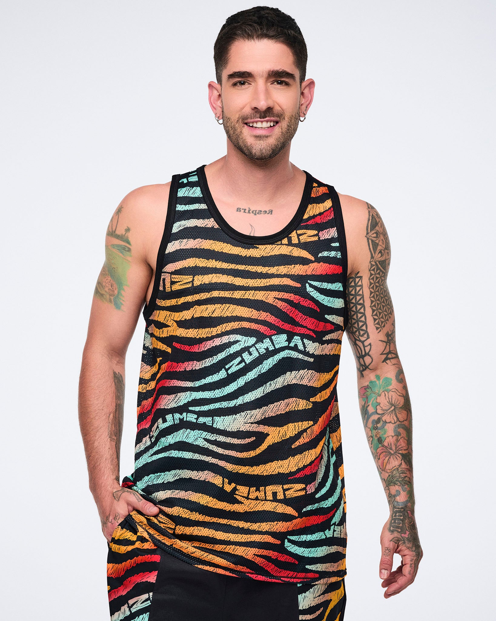 Male model wearing a sleeveless mesh tank in a black zebra-stripe print with multicolor brushstroke stripes in mint, yellow, orange, red, and beige, finished with black trim and a relaxed fit.