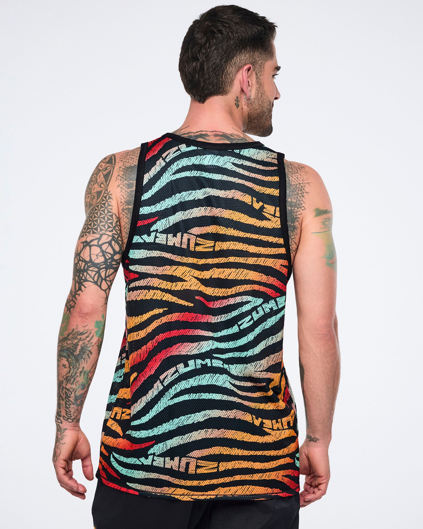 Male model wearing a sleeveless mesh tank in a black zebra-stripe print with multicolor brushstroke stripes in mint, yellow, orange, red, and beige, shown from the back with black trim and a relaxed fit.