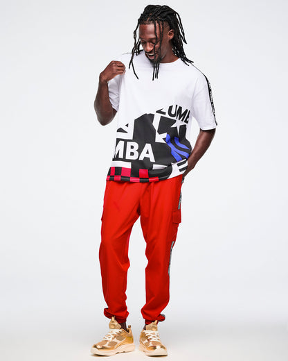 Male model wearing a white t-shirt with black and blue graphics and red pants on a white background.