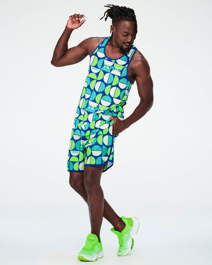Full view of a male model in the dark blue half-circle print racerback tank with matching print shorts and neon green shoes.