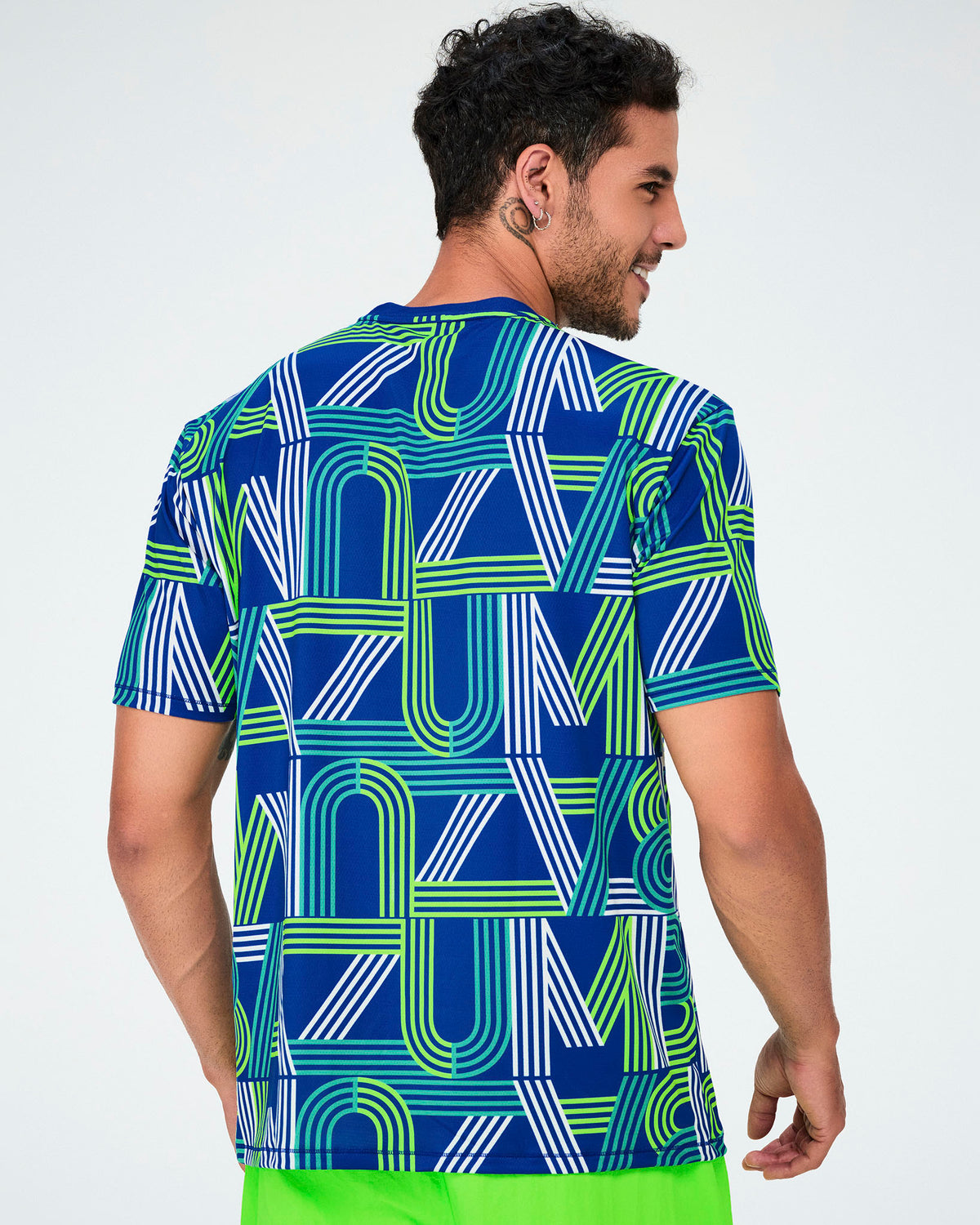 Back view of a male model in the dark blue mesh top, its striped 'ZUMBA' letter print continuing across the back.