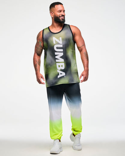 Full view of a male model wearing a black and yellow halftone dot-print tank top with white "ZUMBA" vertical text, ombre, black, white, yellow, joggers, and white sneakers.