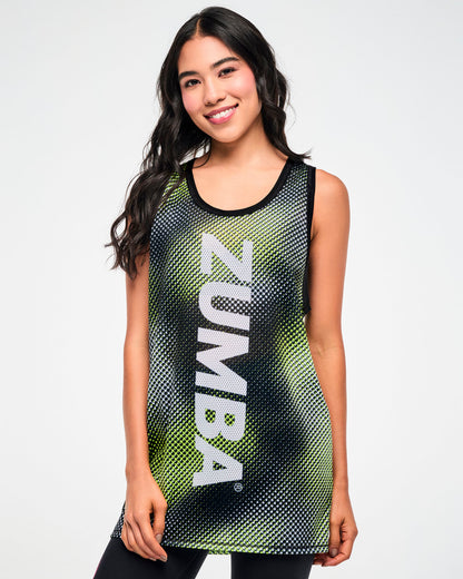 Female model wearing a black and yellow halftone dot-print tank top with "ZUMBA" white vertical text.