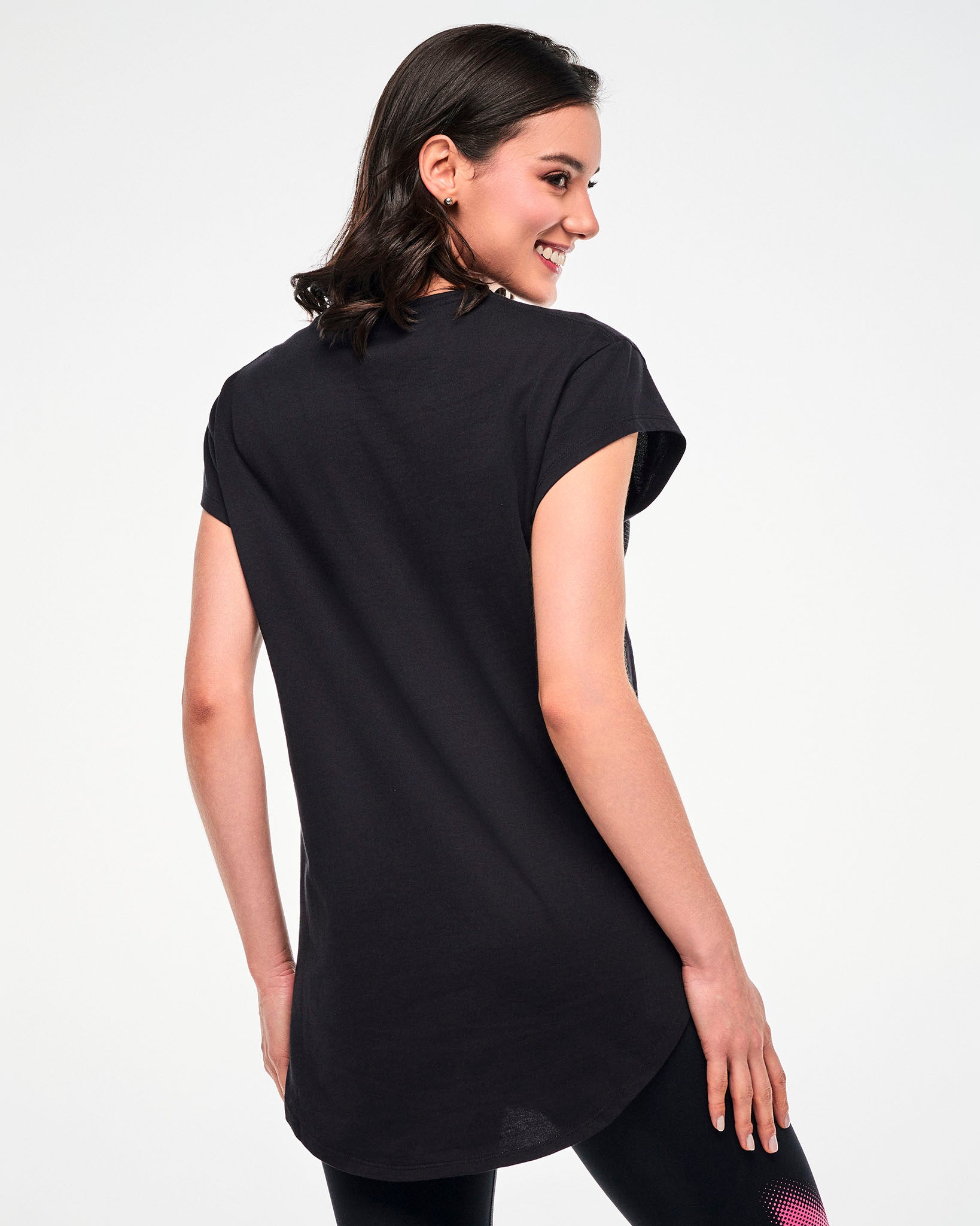 Shown from the back, female model wearing a black tee with a curved hem.