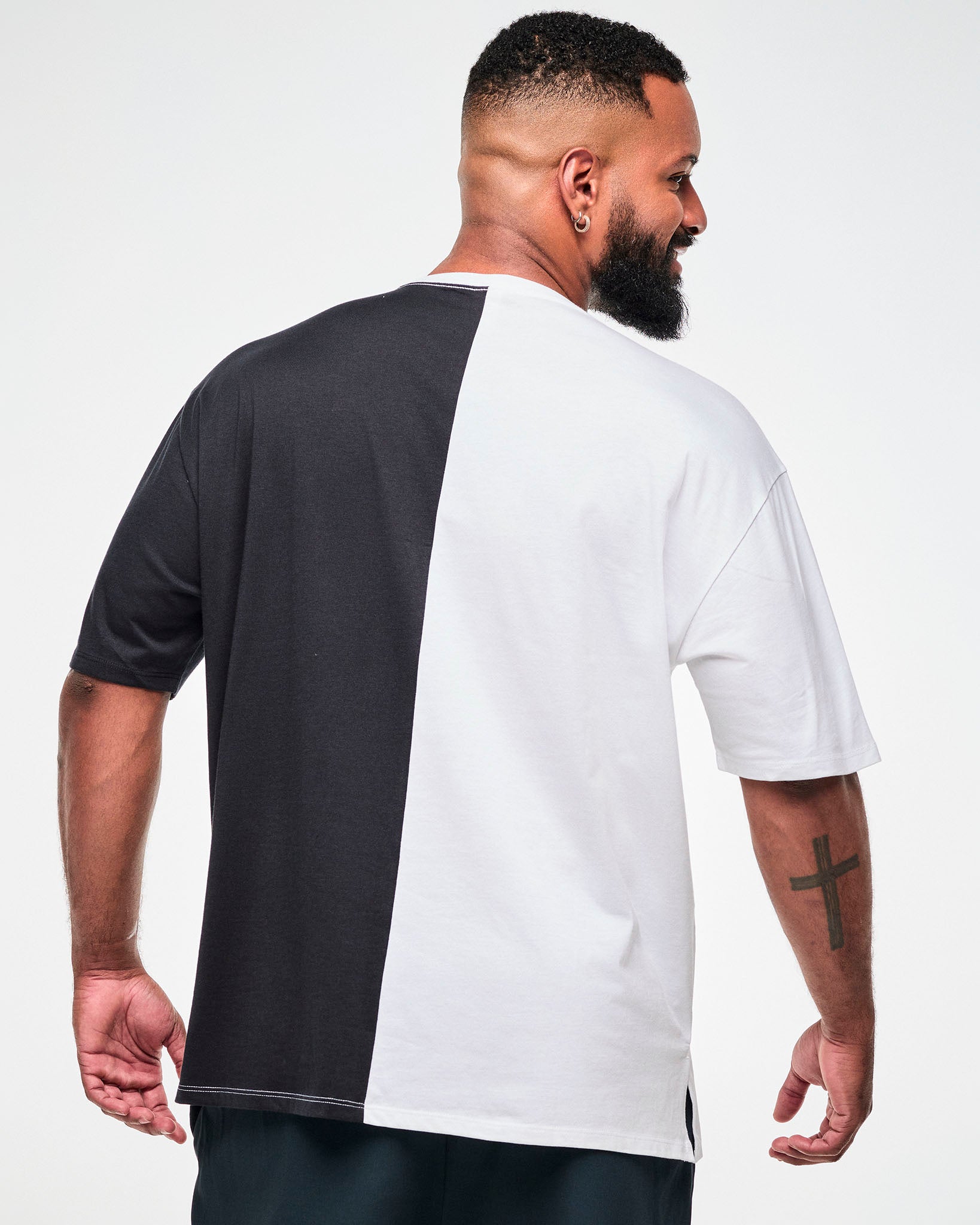 Shown from the back, male model wearing a black and white colorblock oversized T-shirt.