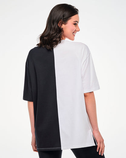 Shown from the back, female model wearing a black and white colorblock oversized T-shirt.