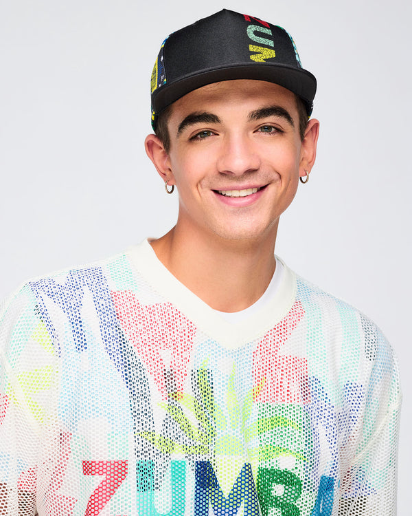 Close-up portrait of the male model wearing the cap forward; the multicolor “ZUMBA” print on the front panel is partially visible above the brim.