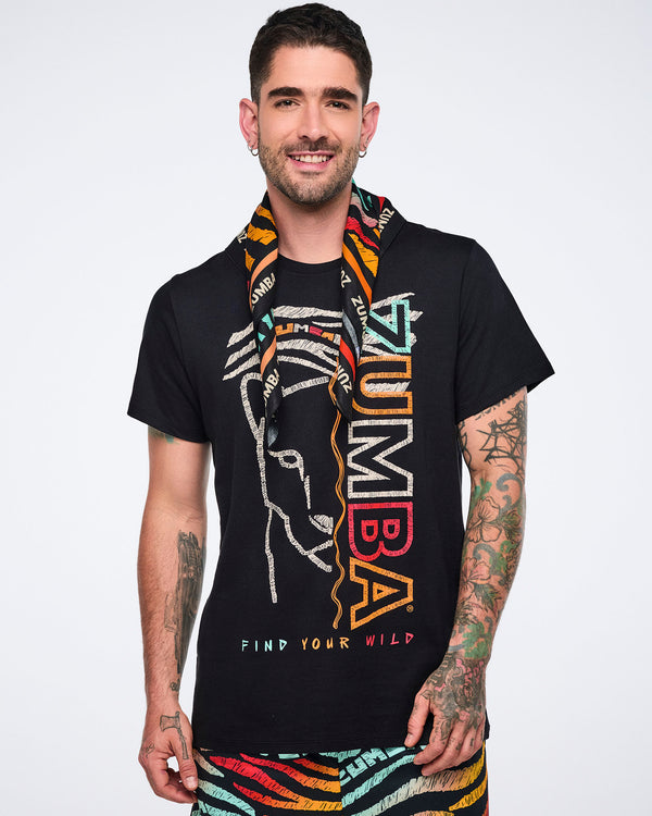 Multicolor Zumba square bandana draped around the neck on a male model. He wears a black graphic Zumba T-shirt and multicolor zebra-print shorts in a front-facing studio portrait.
