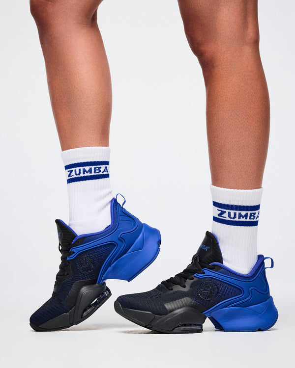 Close-up of female model in S/M white and blue Zumba socks paired with blue and black shoes.