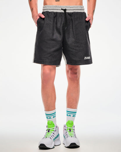 Male model wearing black and grey colorblock shorts with aqua-striped socks and white shoes.