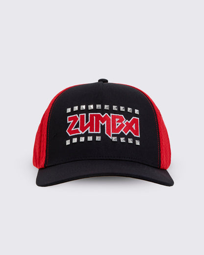 A black trucker-style hat with red mesh side panels and a red embroidered ZUMBA logo outlined in silver studs on the front.