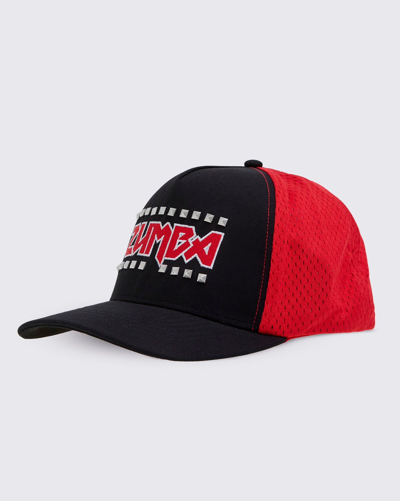 Side view of a two-tone trucker-style baseball cap with a black front panel and brim, and a red mesh back. The front panel features a red and white ZUMBA text with silver metal studs on the top and bottom of the text.